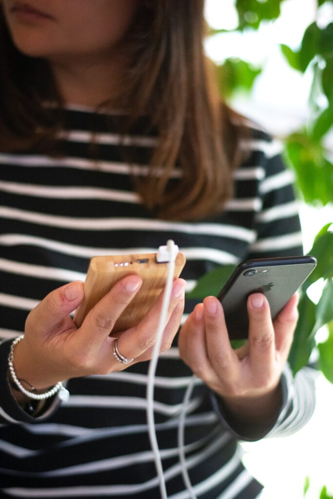 Kobieta trzymająca telefon ładowany przez powerbanka